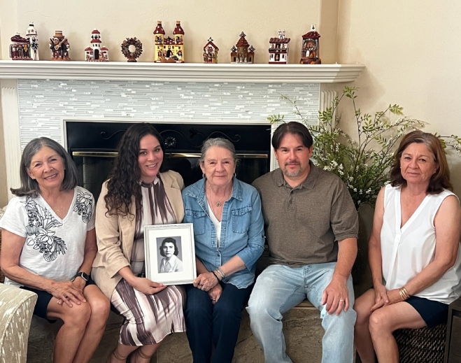 Familia sosteniendo retrato de antepasado